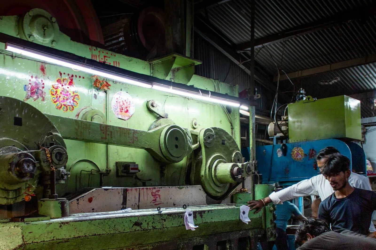 Operario trabajando en una máquina industrial dentro de la nave
